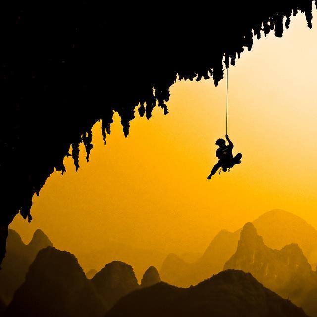 hombre colgado montaña negro oro
