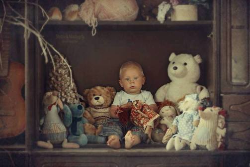 niño entre muñecos